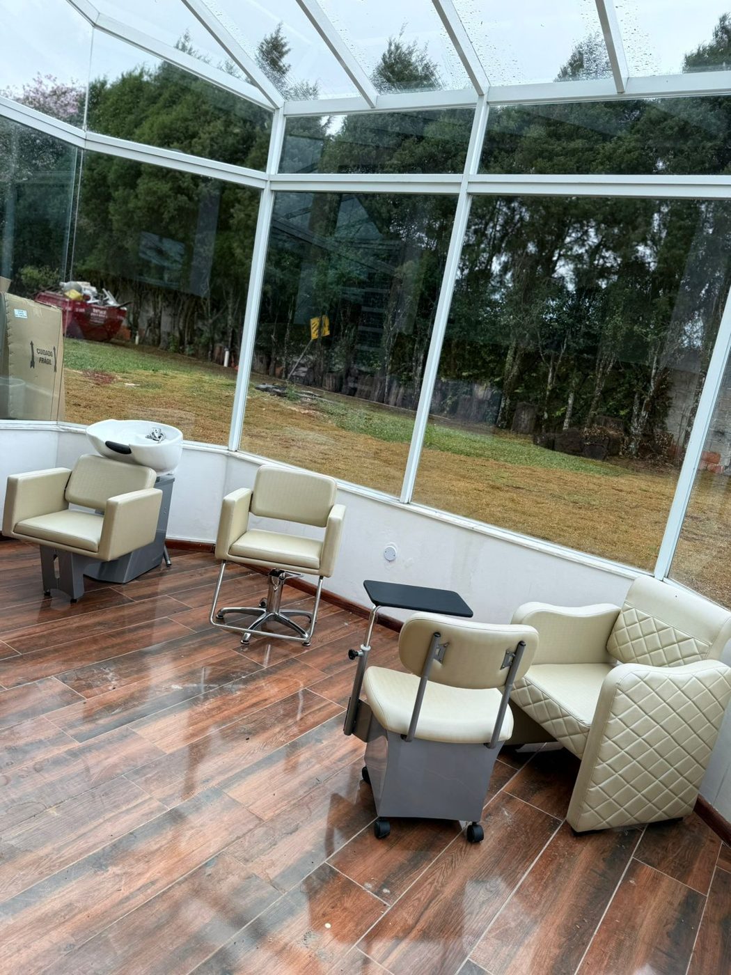 Solário envidraçado com poltronas confortáveis e vista para a área verde