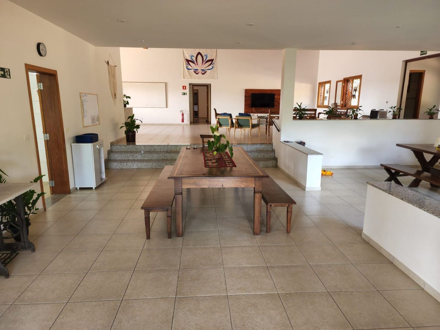 Refeitório com mesas e bancos de madeira em ambiente claro e ventilado